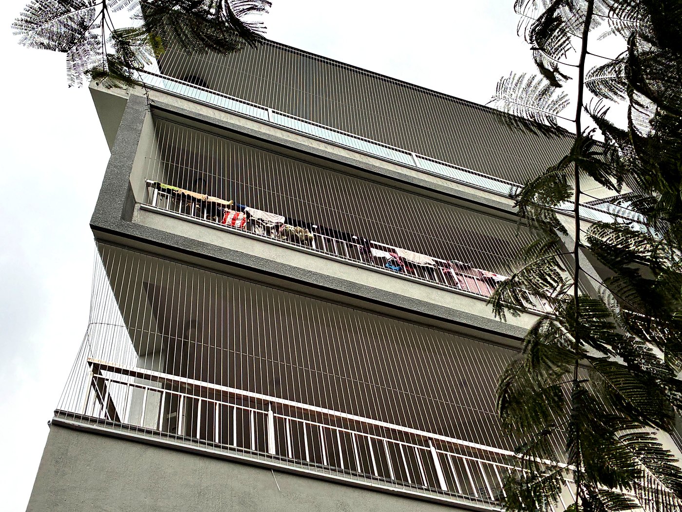 Invisible grills covering balconies on several floors of an apartment building