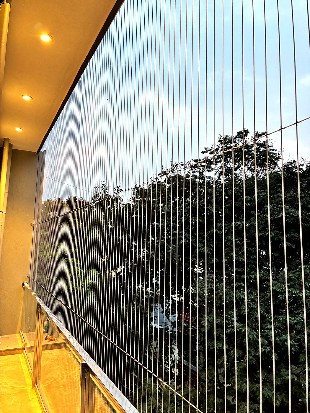 Close view of stainless steel invisible grill cables on a balcony